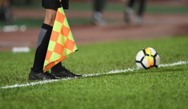 An assistant referee with a flag. Image credit: Chiraphat Phaungmala.