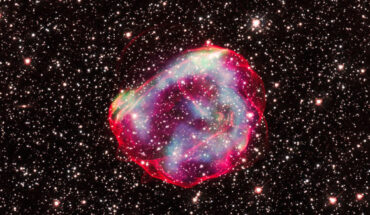 This composite image shows SNR 0519-69.0, a Type Ia supernova remnant in the Large Magellanic Cloud: X-ray data from Chandra with low, medium and high energies are shown in green, blue, and purple respectively, with some of these colors overlapping to appear white; optical data from Hubble shows the perimeter of the remnant in red and stars around the remnant in white. Image credit: NASA / CXC / GSFC / Williams et al. / STScI.