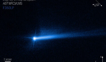 At the top right of the image, there are arrows indicating the direction of impact by NASA’s DART spacecraft. The direction of impact arrow points in the 10 o’clock direction. The ‘to Sun’ arrow points in the 8 o’clock direction. At the bottom right are compass arrows indicating the orientation of the image on the sky. The north arrow points in the directly straight up. The east arrow points to the left in the 9 o’clock direction. Image credit: NASA / ESA / STScI / Jian-Yang Li, PSI / Joseph DePasquale.
