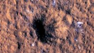 Boulder-size blocks of water ice can be seen around the rim of an impact crater in the Amazonis Planitia regionon Mars, as viewed by the High-Resolution Imaging Science Experiment (HiRISE) aboard NASA’s Mars Reconnaissance Orbiter. Image credit: NASA / JPL-Caltech / University of Arizona.