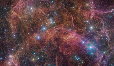 This image, taken by the OmegaCAM camera at ESO’s VLT Survey Telescope, shows a spectacular view of the orange and pink clouds that make up the Vela SNR. OmegaCAM can take images through several filters that let through light of different colors. In this particular image of the Vela SNR, four different filters were used, represented here by a combination of magenta, blue, green and red. Image credit: ESO / VPHAS+ Team / Cambridge Astronomical Survey Unit.