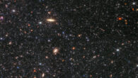 This image, taken by the Near-Infrared Camera aboard the NASA/ESA/CSA James Webb Space Telescope, displays countless stars in the dwarf irregular galaxy Wolf-Lundmark-Melotte as well as dozens of background galaxies. The image includes 0.9-micron light shown in blue, 1.5-micron in cyan, 2.5-micron in yellow, and 4.3-micron in red. Image credit: NASA / ESA / CSA / STScI / K. McQuinn, Rutgers University / A. Pagan, STScI.