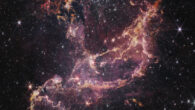 This image, taken by the Near-Infrared Camera (NIRCam) onboard the NASA/ESA/CSA James Webb Space Telescope, shows the star cluster NGC 346. Webb reveals the presence of many more building blocks than previously expected, not only for stars, but also planets, in the form of clouds packed with dust and hydrogen. The plumes and arcs of gas in this image contains two types of hydrogen. The pink gas represents energized hydrogen, which is typically as hot as around 10,000 degrees Celsius (approximately 18,000 degrees Fahrenheit) or more, while the more orange gas represents dense, molecular hydrogen, which is much colder at around minus 200 degrees Celsius or less (approximately minus 300 degrees Fahrenheit), and associated dust. The colder gas provides an excellent environment for stars to form, and, as they do, they change the environment around them. The effect of this is seen in the various ridges throughout, which are created as the light of these young stars breaks down the dense clouds. The many pillars of glowing gas show the effects of this stellar erosion throughout the region. In this image blue was assigned to the wavelength of 2.0 microns (F200W), green was assigned to 2.77 microns (F277W), orange was assigned to 3.35 microns (F335M), and red was assigned to 4.44 microns (F444W). Image credit: NASA / ESA / CSA / O. Jones, UK ATC / G. De Marchi, ESTEC / M. Meixner, USRA / A. Pagan, STScI / N. Habel, USRA / L. Lenkic, USRA / L. Chu, NASA’s Ames Research Center.