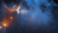 This Webb image features the central region of the Chameleon I dark molecular cloud, which resides 630 light-years away in the constellation of Chamaeleon; the cold, wispy cloud material (blue, center) is illuminated in the infrared by the glow of the young, outflowing protostar Ced 110 IRS 4 (orange, upper left); the light from numerous background stars, seen as orange dots behind the cloud, can be used to detect ices in the cloud, which absorb the starlight passing through them. Image credit: NASA / ESA / CSA / M. Zamani, ESA & Webb / F. Sun, Steward Observatory / Z. Smith, Open University / Ice Age ERS Team.