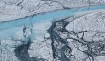 A large stream of meltwater (about 5 to 10 m in width) emerges from an upstream supraglacial lake in the Greenlandic ice on July, 21 2012. The darker shapes are minor streams covered by cryoconite (a mix of dust particles, soot, meteorite dust and organic material) which covers the ice sheet. Cracks cutting through the streams are visible. Along these cracks water can flow through, enlarging them and, eventually, generating moulins that can deliver meltwater through the ice. Image credit: M. Tedesco / CCNY / NASA ICE.