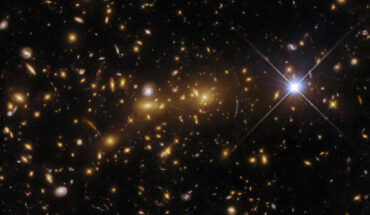 This Hubble image shows eMACS J1353.7+4329, a lensing galaxy cluster some 8 billion light-years away in the constellation of Canes Venatici. Image credit: NASA / ESA / Hubble / H. Ebeling.