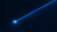 This Hubble image of Dimorphos was taken on December 19, 2022, nearly four months after the asteroid was impacted by NASA’s DART mission. Dimorphos has a blue dust tail extending diagonally to the upper right. A cluster of blue dots surrounds the asteroid. These are boulders that were knocked off the asteroid. Image credit: NASA / ESA / D. Jewitt, UCLA.