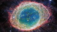 This image from Webb’s NIRCam instrument shows the Ring Nebula. The nebula’s inner cavity hosts shades of blue and green, while the detailed ring transitions through shades of orange in the inner regions and pink in the outer region. The ring’s inner region has distinct filament elements. Image credit: NASA / ESA / CSA / Webb / M. Barlow / N. Cox / R. Wesson.