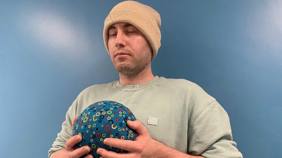 University of Bath Ph.D. student Alexz Farrall with a PAWS ‘breathing’ ball. Image credit: University of Bath.
