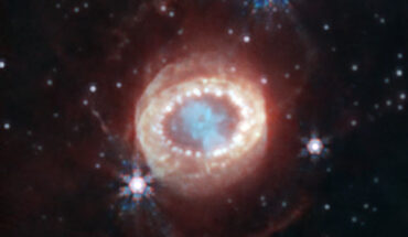 This image of SNR 1987A was taken with Webb’s Near-Infrared Camera. At the center, material ejected from the supernova forms a keyhole shape. Just to its left and right are faint crescents newly discovered by Webb. Beyond them an equatorial ring, formed from material ejected tens of thousands of years before the supernova explosion, contains bright hot spots. Exterior to that is diffuse emission and two faint outer rings. Image credit: NASA / ESA / CSA / M. Matsuura, Cardiff University / R. Arendt, NASA’s Goddard Spaceflight Center & University of Maryland, Baltimore County / C. Fransson.