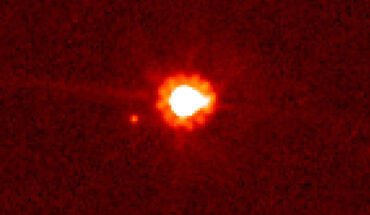 This image, taken with the NASA/ESA Hubble Space Telescope on August 30, 2006, shows the dwarf planet Eris (center) and its moon Dysnomia. Image credit: NASA / ESA / M. Brown, California Institute of Technology.