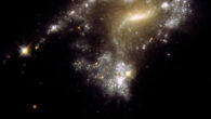 The galaxy AM 1054-325 has been distorted into an S-shape from a normal pancake-like spiral shape by the gravitational pull of a neighboring galaxy, seen in this Hubble image; a consequence of this is that clusters of newborn stars form along a stretched-out tidal tail for thousands of light-years, resembling a string of pearls. Image credit: NASA / ESA / STScI / Jayanne English, University of Manitoba.