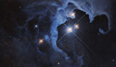 HP Tau, a trio of dazzling stars some 550 light-years away in the constellation of Taurus, blaze brilliantly from the hollowed-out cavity of a reflection nebula in the new Hubble image. Image credit: NASA / ESA / G. Duchene, Universite de Grenoble I / Gladys Kober, NASA & Catholic University of America.