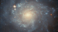 In this image of the barred spiral galaxy NGC 5668, Hubble was used to examine the surroundings of the Type II supernova event labeled SN 2004G, seeking to study the kinds of stars that end their lives as this kind of supernova. The color image is composed of near-infrared and optical observations from Hubble’s Advanced Camera for Surveys (ACS). Two filters were used to sample various wavelengths. The color results from assigning different hues to each monochromatic image associated with an individual filter. Image credit: NASA / ESA / Hubble / C. Kilpatrick.