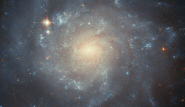 In this image of the barred spiral galaxy NGC 5668, Hubble was used to examine the surroundings of the Type II supernova event labeled SN 2004G, seeking to study the kinds of stars that end their lives as this kind of supernova. The color image is composed of near-infrared and optical observations from Hubble’s Advanced Camera for Surveys (ACS). Two filters were used to sample various wavelengths. The color results from assigning different hues to each monochromatic image associated with an individual filter. Image credit: NASA / ESA / Hubble / C. Kilpatrick.
