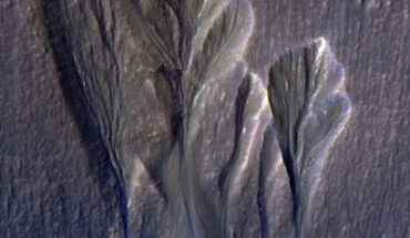 The white edges along these gullies in Mars’ Terra Sirenum are believed to be dusty water ice. Khuller et al. think meltwater could form beneath the surface of this kind of ice, providing a place for possible photosynthesis. Image credit: NASA / JPL-Caltech / University of Arizona.