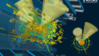 Display of a lead-lead collision at 5.02 TeV per nucleon pair that resulted in a candidate pair of top quarks that decay into other particles. The event contains four particle jets (yellow cones), one electron (green line) and one muon (red line). The inlay shows an axial view of the event. Image credit: ATLAS / CERN.