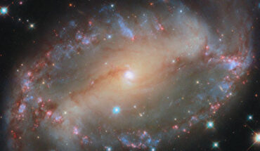 A prominent bar of stars stretches across the center of the barred spiral galaxy NGC 2566, and spiral arms emerge from each end of the bar. Image credit: NASA / ESA / Hubble / D. Thilker.