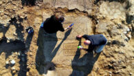 IAA archaeologists cleaning the ancient mosaic of a Byzantine-period monastery at Kiryat Gat, Israel. Image credit: Emil Aladjem, Israel Antiquities Authority.