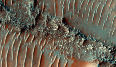 This HiRISE image shows a flat top, heavily eroded fluvial sinuous ridge on Mars; sand dunes can be seen migrating over the top of the fluvial sinuous ridge. Image credit: NASA / JPL / University of Arizona.