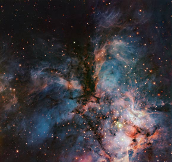 This VLT/HAWK-I image shows the emission nebula RCW 36; while the dark clouds in the middle of the image make up the head and body of the bird of prey, the filaments extending away from the body to the left and right compose its wings; below it, is a mesmerising blue nebula with massive newly born stars, whose intense radiation make the gas around them glow brightly. Image credit: ESO / do Brito do Vale et al.