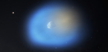 An artist’s impression of 3I/ATLAS is shown as it passes near the Sun, illuminating one side of the comet; on the side of the comet closer to the Sun, the methanol gas is shown in blue, with icy dust grains still present in the gas; on the dark side of the comet, the hydrogen cyanide is shown in orange. Image credit: NSF / AUI / NRAO / M.Weiss.