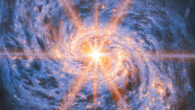 This image of Messier 77 from Webb’s Mid-Infrared Instrument (MIRI) highlights its swirling spiral arms, the dust in its disk and its piercingly bright core like never before. The bright orange lines appearing to radiate out from the galaxy’s center are not actually a feature of the galaxy: they are a type of distortion that arises from the optical design of the telescope. Called diffraction spikes, they are created because the intense light from the unresolved AGN is bent (diffracted) very slightly at the edges of Webb’s hexagonal mirror panels and around one of the struts that hold up its secondary mirror. Image credit: NASA / ESA / CSA / Webb / A. Leroy.