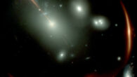 This Webb image shows the highly distorted red galaxy MRG-M0138 seen through a foreground cluster of galaxies (white sources). Image credit: NASA / ESA / CSA / Webb.