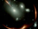 This Webb image shows the highly distorted red galaxy MRG-M0138 seen through a foreground cluster of galaxies (white sources). Image credit: NASA / ESA / CSA / Webb.