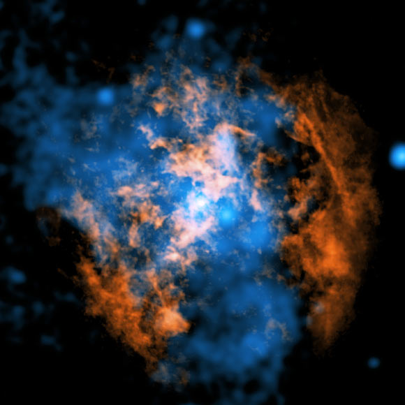 This image shows the evidence for the wind blowing away from Sagittarius A*: the white dot in the center of the image shows the supermassive black hole; in orange is data from ALMA, mapping the location of cold gas composed of carbon monoxide in the image; in blue is X-ray data from Chandra; a large cone-shaped cavity, visible as an absence of cold gas in the ALMA data, is filled by hot X-ray-emitting gas in the Chandra data. Image credit: NASA / CXC / UMass / Wang et al. / ALMA / ESO / NAOJ / NRAO / Longmore et al. / Minniti et al.