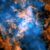 This image shows the evidence for the wind blowing away from Sagittarius A*: the white dot in the center of the image shows the supermassive black hole; in orange is data from ALMA, mapping the location of cold gas composed of carbon monoxide in the image; in blue is X-ray data from Chandra; a large cone-shaped cavity, visible as an absence of cold gas in the ALMA data, is filled by hot X-ray-emitting gas in the Chandra data. Image credit: NASA / CXC / UMass / Wang et al. / ALMA / ESO / NAOJ / NRAO / Longmore et al. / Minniti et al.