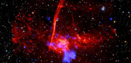 This composite image contains X-rays from Chandra and XMM-Newton missions (shown in blue) as well as radio data from the MeerKAT telescope (shown in red) in South Africa. These have been combined with an optical image from the Pan-STARRS telescopes in Hawai’i (red, green, and blue). Image credit: NASA / CXC / UCLA / Zhu et al. / ESA / XMM-Newton / PanSTARRS / MeerKAT / CSA / STScI / SAO / L. Frattare & P. Edmonds.