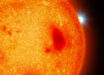 An artist’s impression of a red dwarf with a white dwarf binary companion peeking out from behind. Image credit: Mark A. Garlick / University of Warwick.