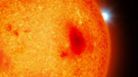 An artist’s impression of a red dwarf with a white dwarf binary companion peeking out from behind. Image credit: Mark A. Garlick / University of Warwick.