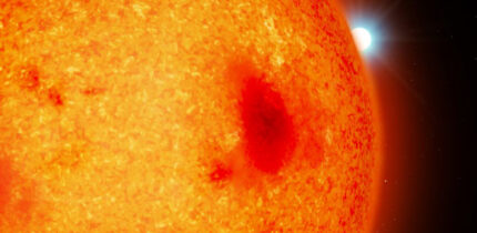 An artist’s impression of a red dwarf with a white dwarf binary companion peeking out from behind. Image credit: Mark A. Garlick / University of Warwick.