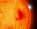 An artist’s impression of a red dwarf with a white dwarf binary companion peeking out from behind. Image credit: Mark A. Garlick / University of Warwick.