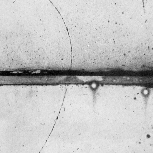 Cloud chamber photograph by the American experimental physicist Carl David Anderson of the first positron ever identified.